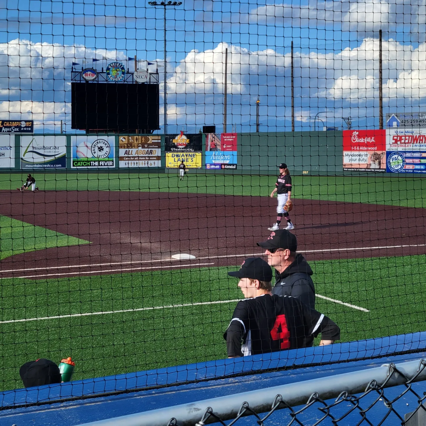 Picture of Brad and Ryan watching a high school game on the Aquasox home field.