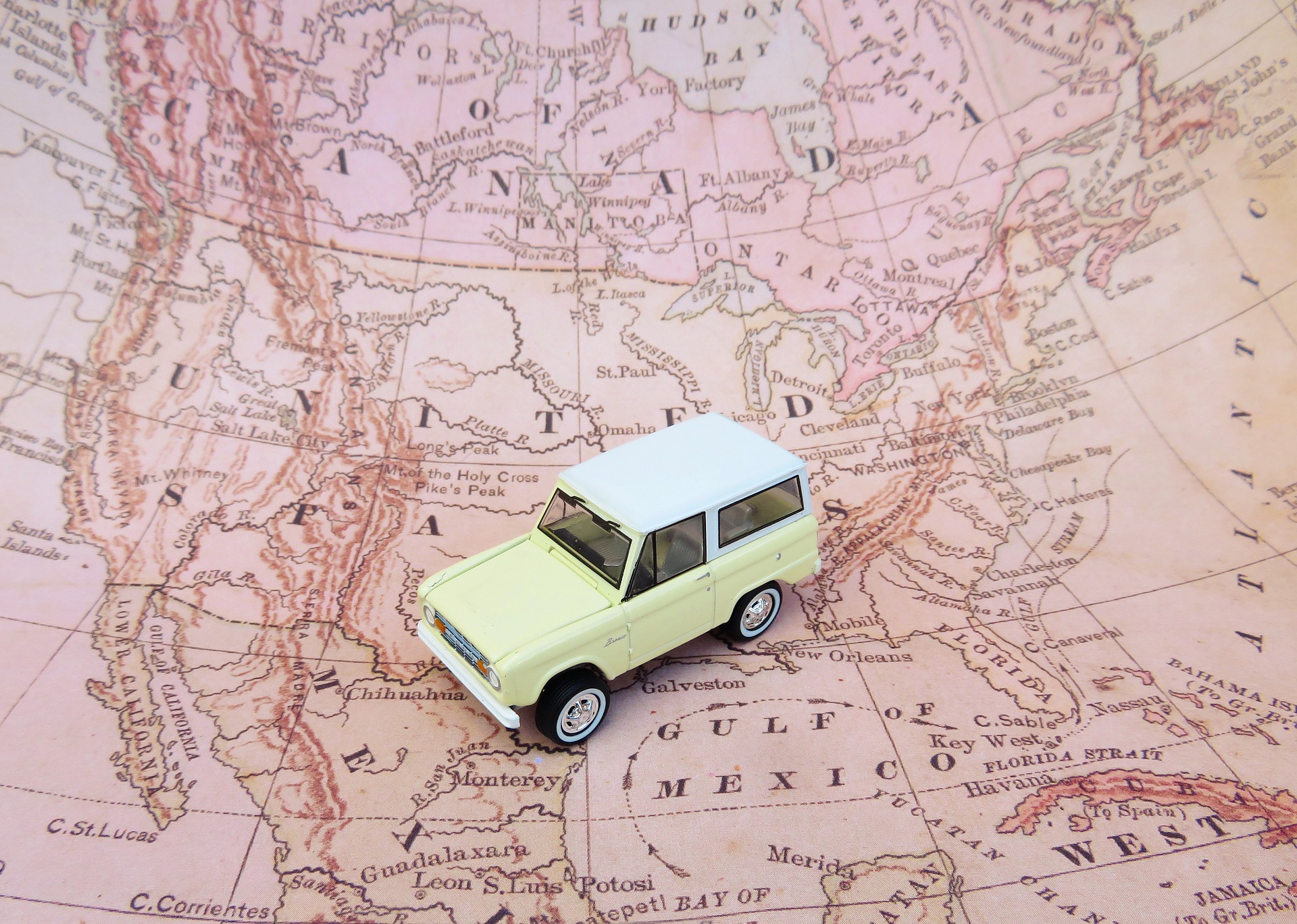 map of the United States with a toy car sitting on top of it, symbolizing the project of mapping out your baseball road trip